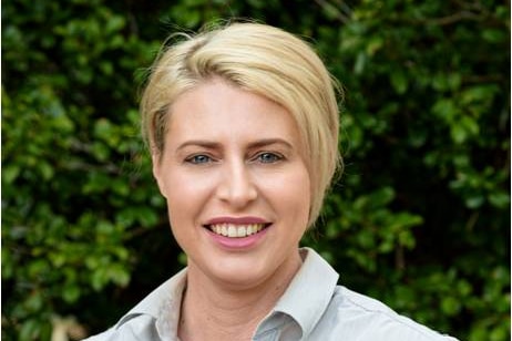 A woman smiles at the camera.