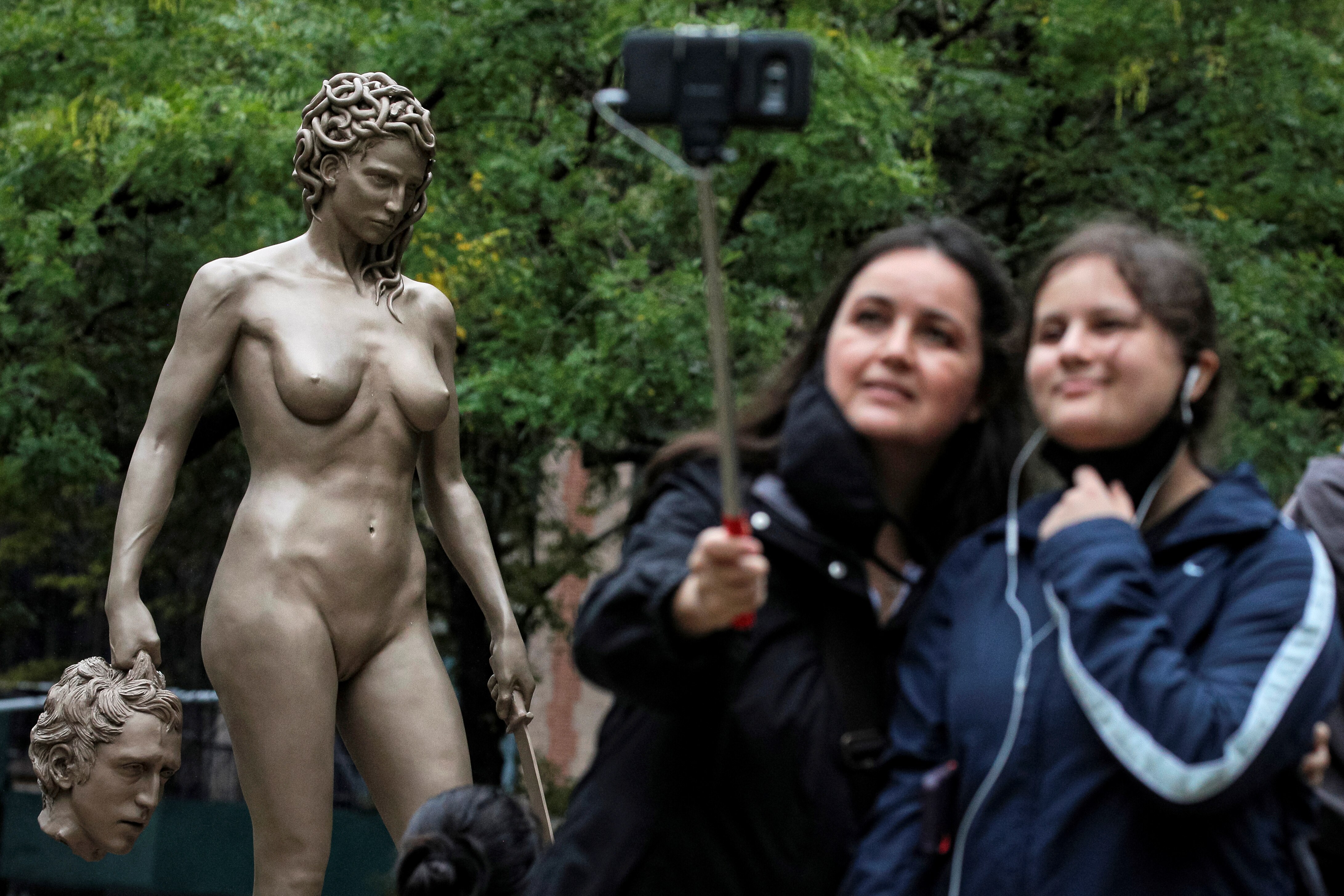 People take a selfie in front of 'Medusa With The Head of Perseus', in New York.
