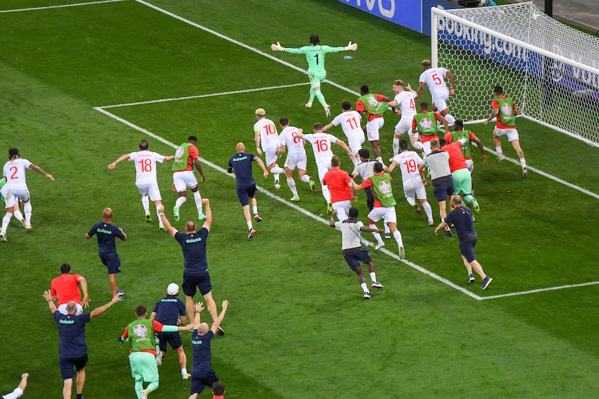 The entire Switzerland team, including substitutes and some staff, chase after the goalkeeper