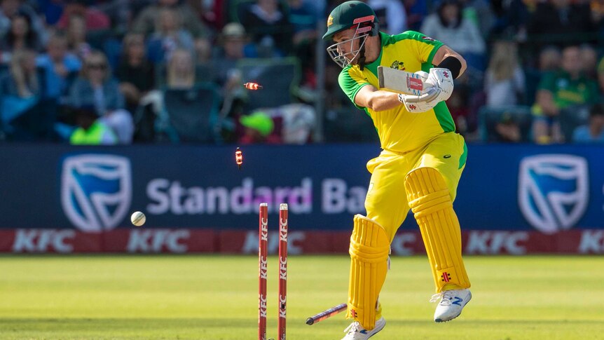 Aaron Finch is in an awkward position on the back foot. Meanwhile, his off stump does a cartwheel and the bails fly