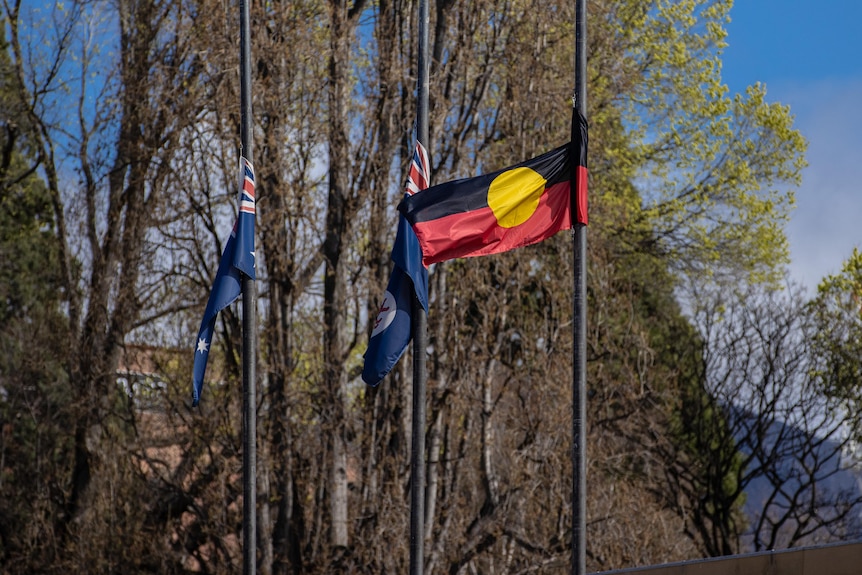 A trio of flags fly at half-mast.