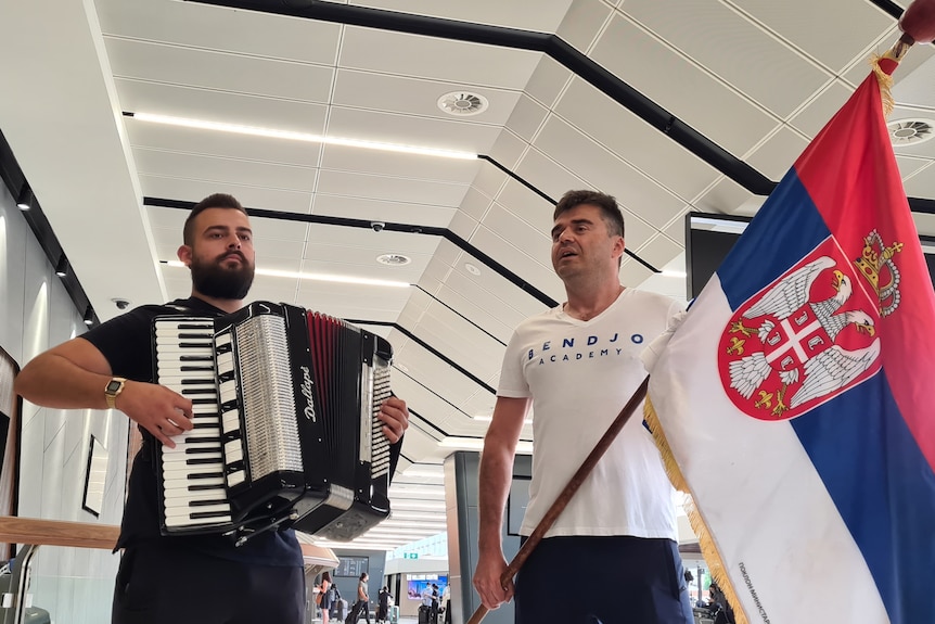 Two men with a Serbian flag.