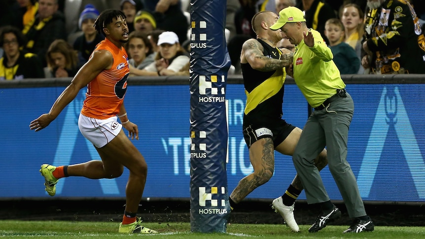 AFL player collides with the goal umpire during a match