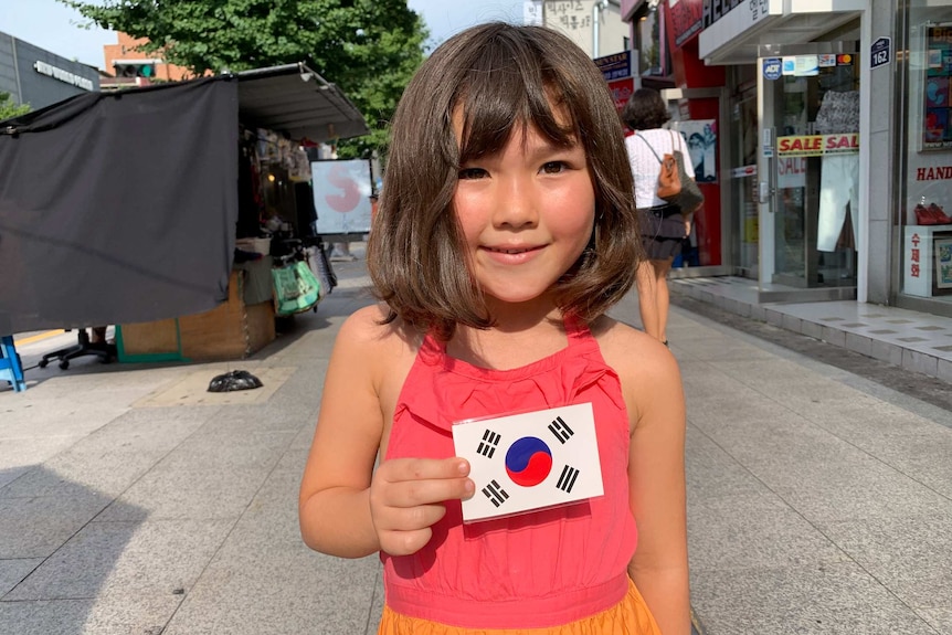 Juna in holding a Korean flag in Korea for New Format for Living