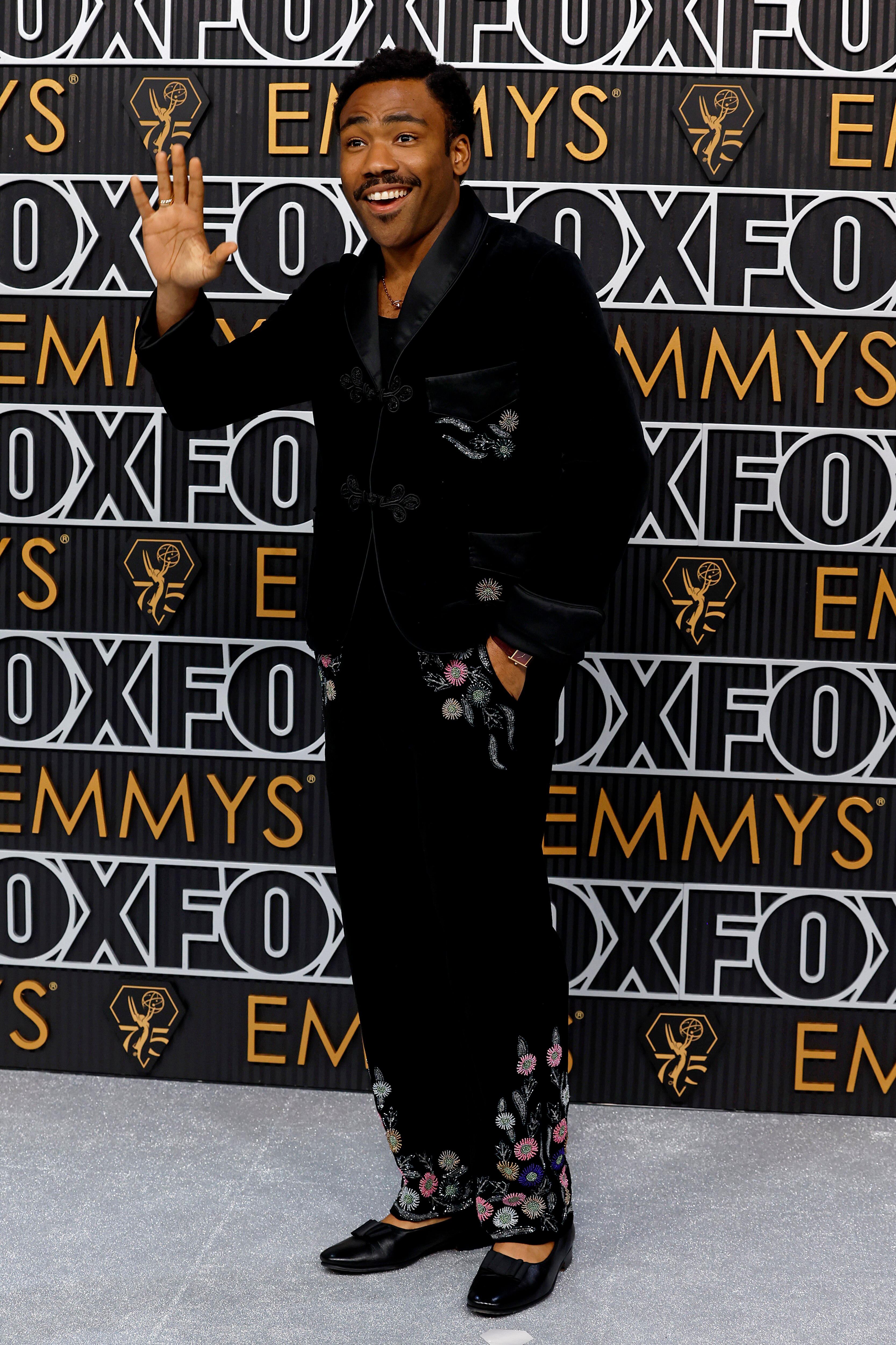 A man in a black suit on the red carpet