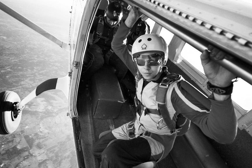 Black and white photo of Brett Dummett about to jump out of a plane