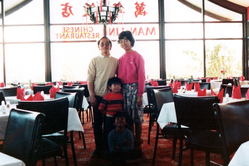 Two parents and their two kids in the dining room of a Chinese restaurant.