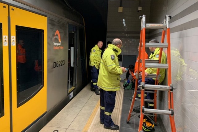 workers next to a train on a platform