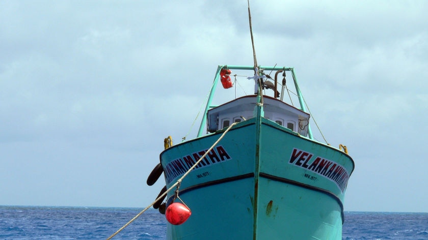 An asylum seeker boat floats in waters