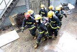 Chinese firefighters evacuate an injured worker from the Baoyuan poultry plant that caught fire in Dehui.