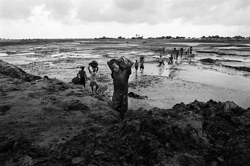 A young Rohingya boy hauls mud at a worksite.