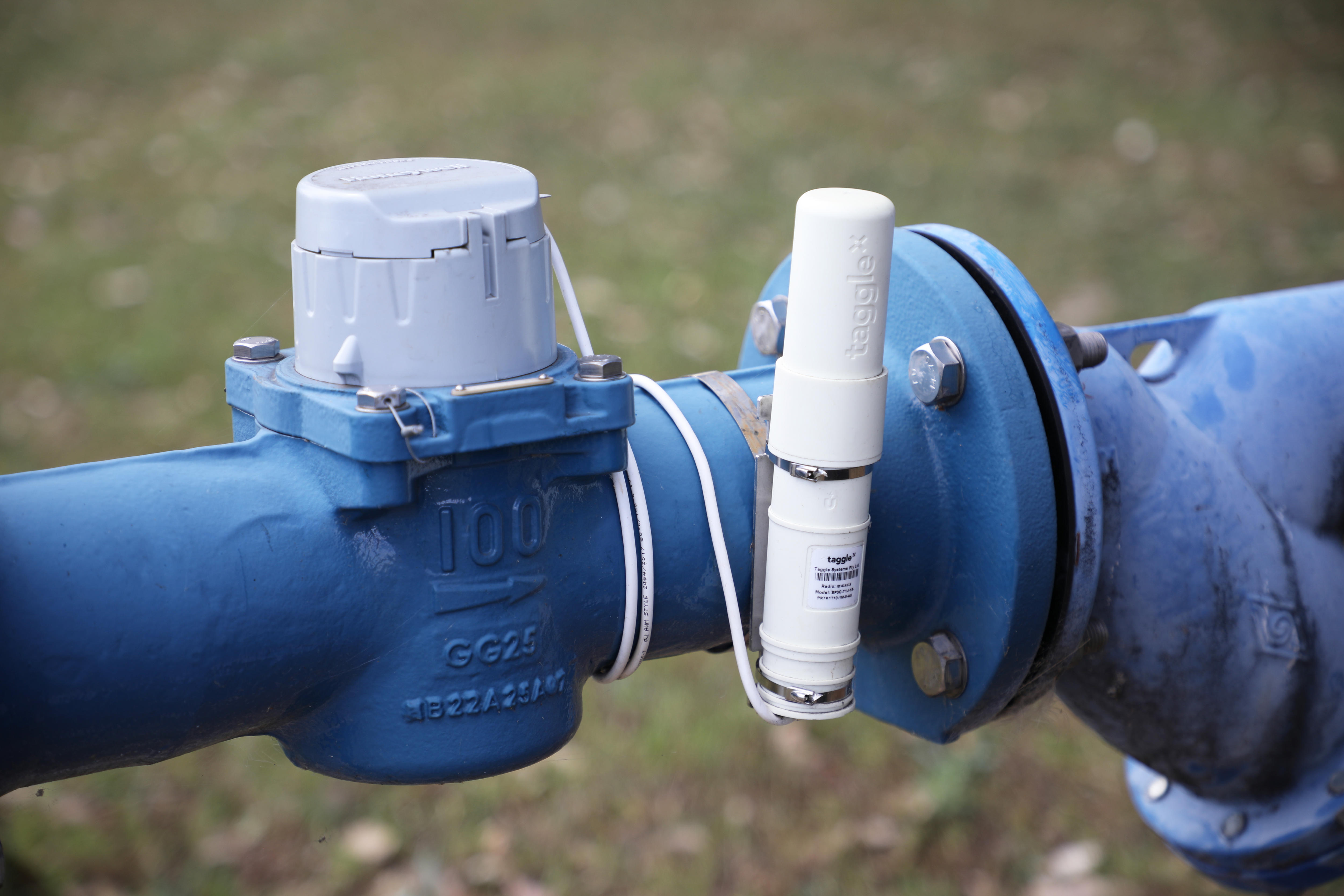 A water meter with a small white device attached.