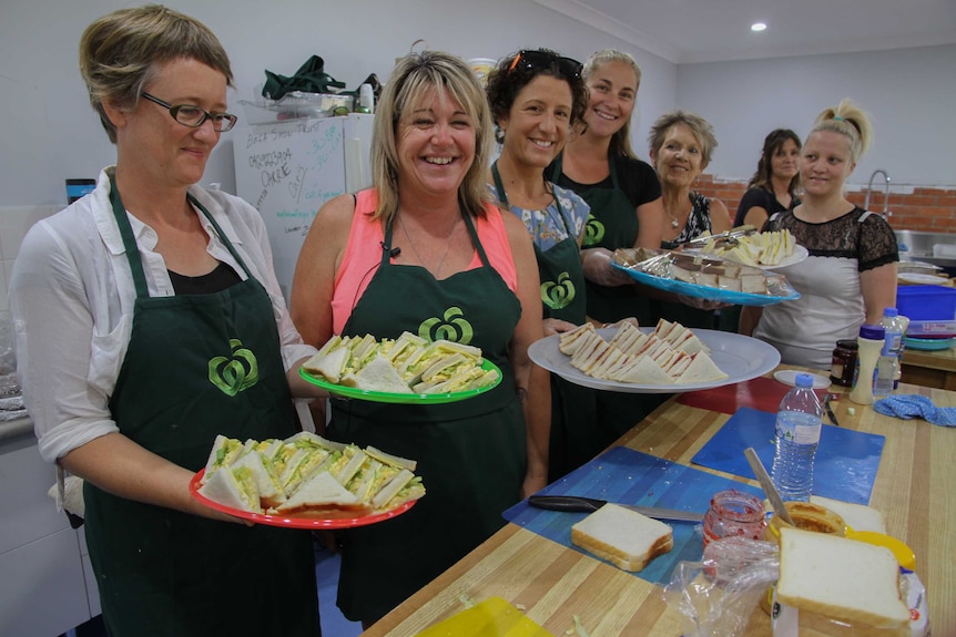 Women hold plates of sandwiches