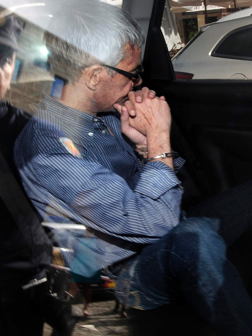 Francisco Jose Garzon Amo sits in the back of a police car as he is transferred to the courthouse.