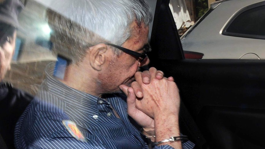 Francisco Jose Garzon Amo sits in the back of a police car as he is transferred to the courthouse.