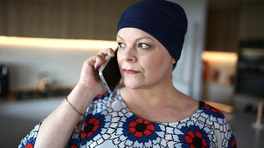 A woman wearing a head scarf using the phone.