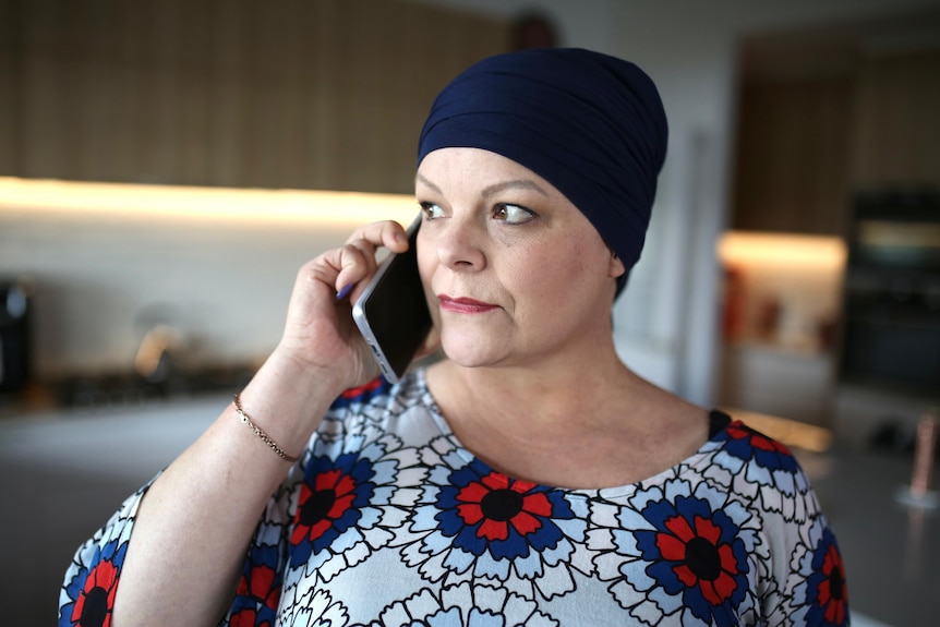 A woman wearing a head scarf using the phone.