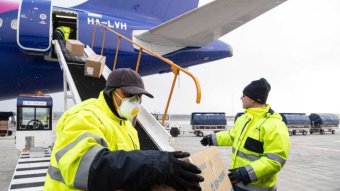 People unload boxes as Chinese aid arrives in Hungary.