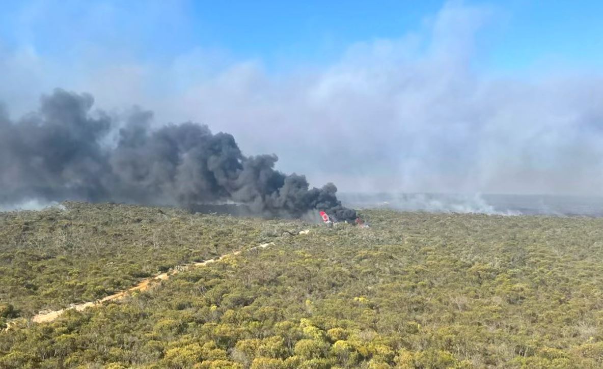 A smoke plume coming out of bushland in an aerial shot. 