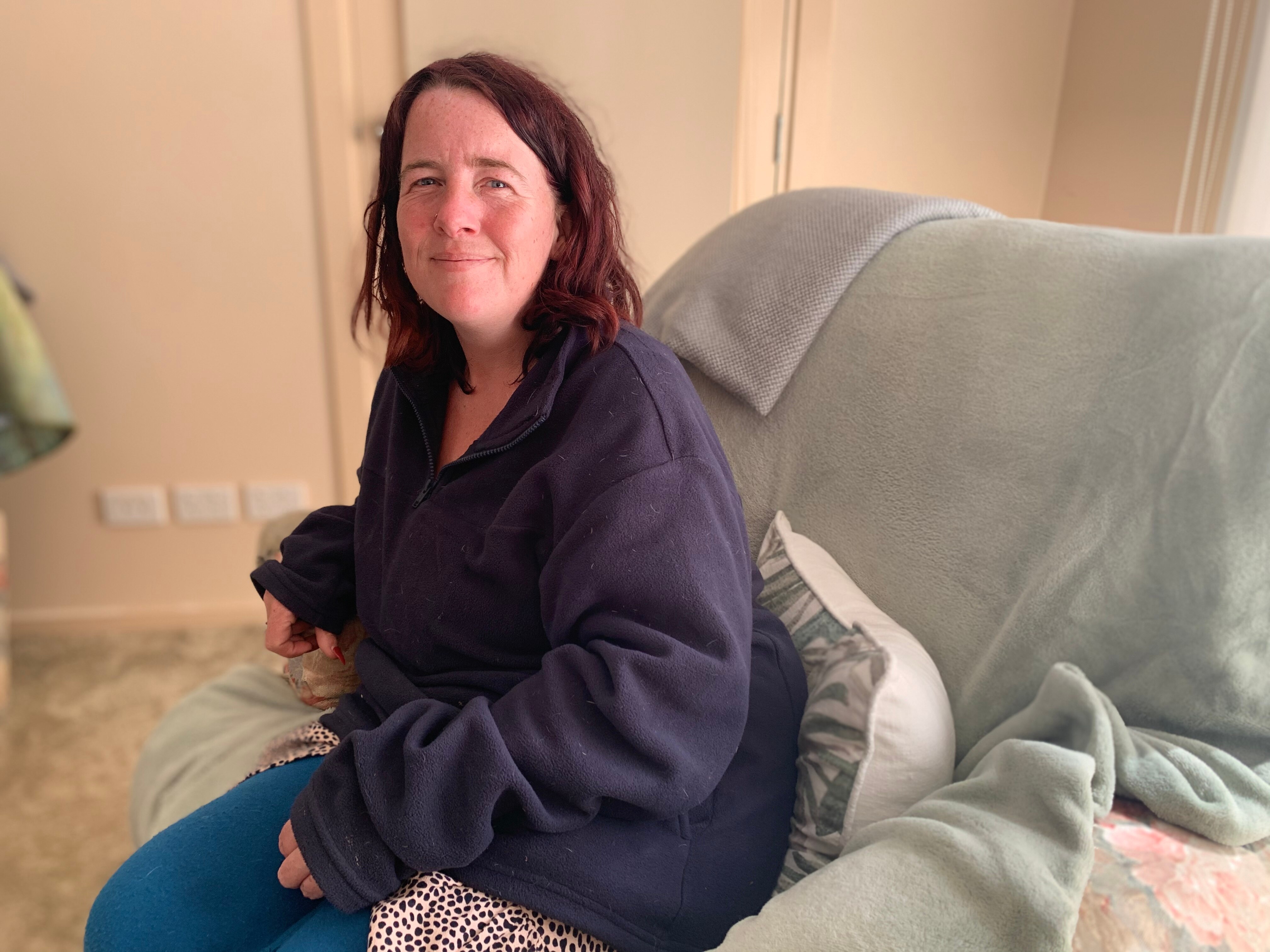 Hope, a woman in her mid 30s sits on a lounge chair