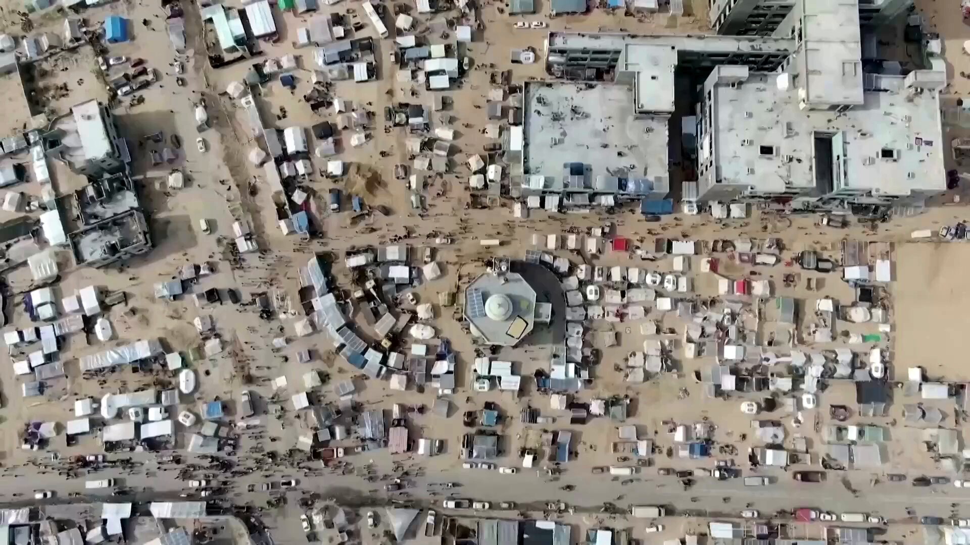 aerial of a street in gaza crowded with tents and refugee structures 