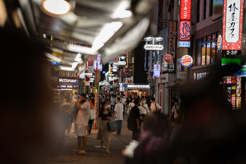 A crowded street in Tokyo at night