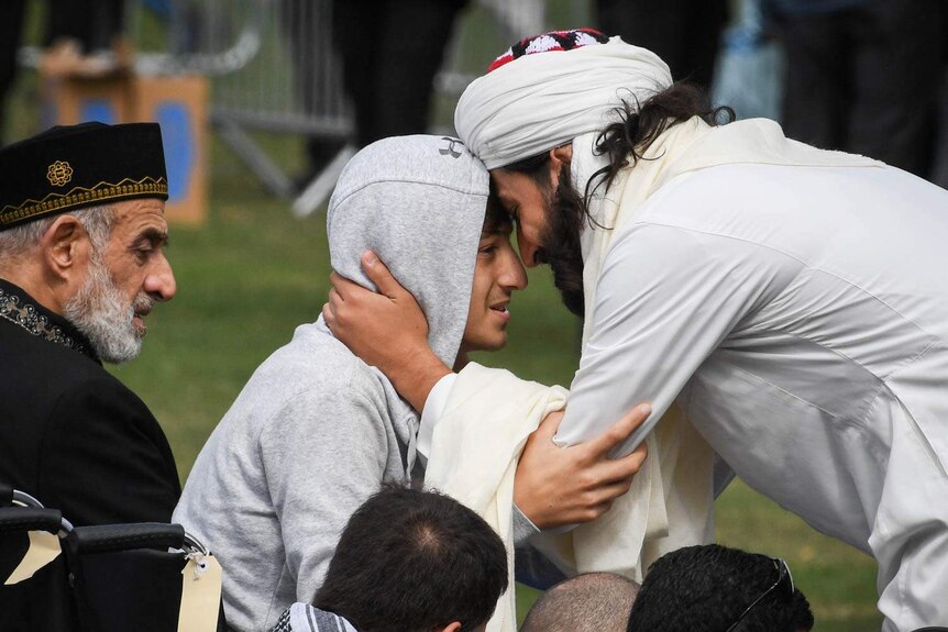 A man wearing a head dress puts his forehead against that of teenager Zaid Mustafa.