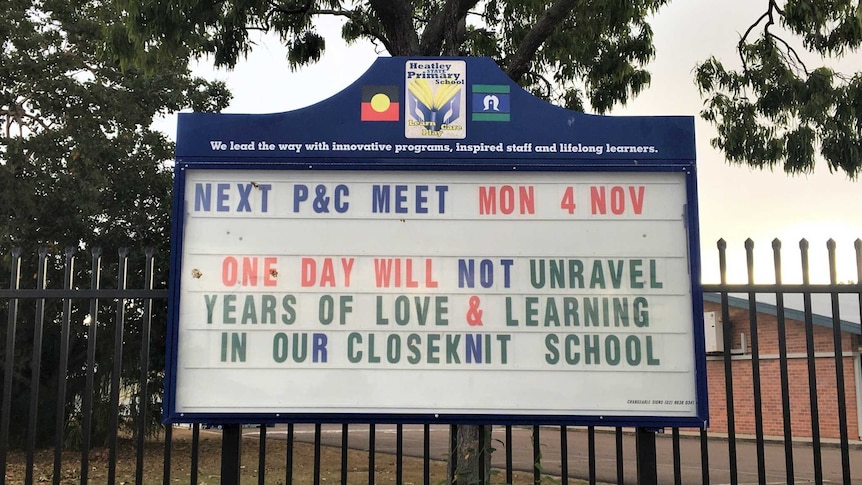 The school sign reads "One day will not unravel years of love and learning in our close knit school"