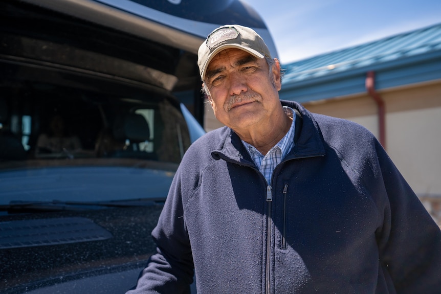 Man wearing a navy jacket and cap.