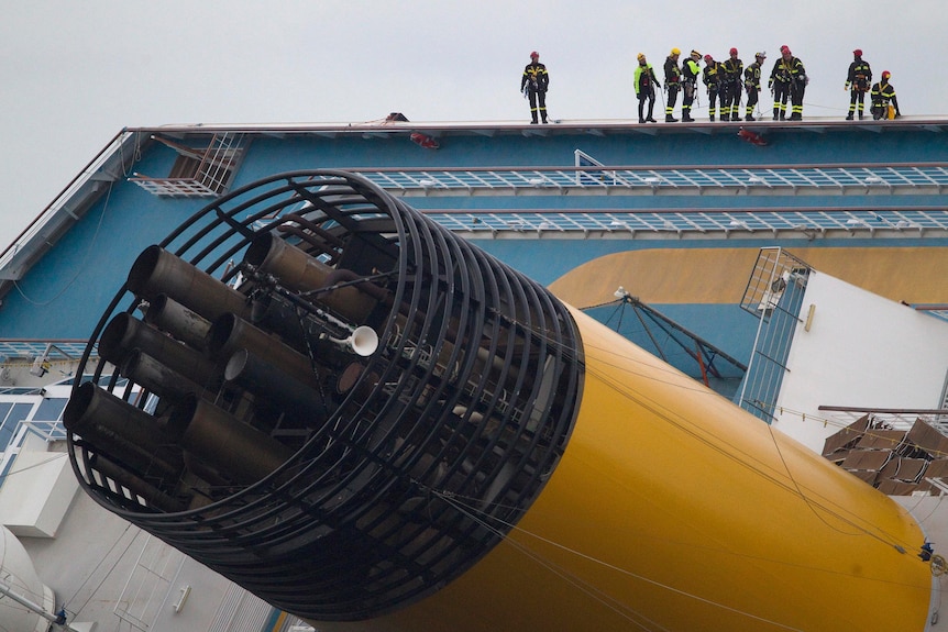 Rescue workers stand on top of the Costa Concordia.
