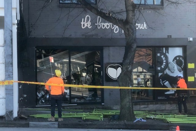 Workers stand in front of 'The Booty Parlour' which has been taped off