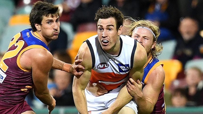 Jeremy Cameron handballs against the Brisbane Lions.