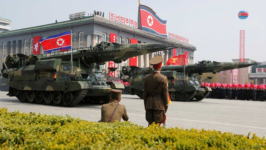 Missiles are driven past the stand with North Korean leader Kim Jong Un and other high ranking officials.