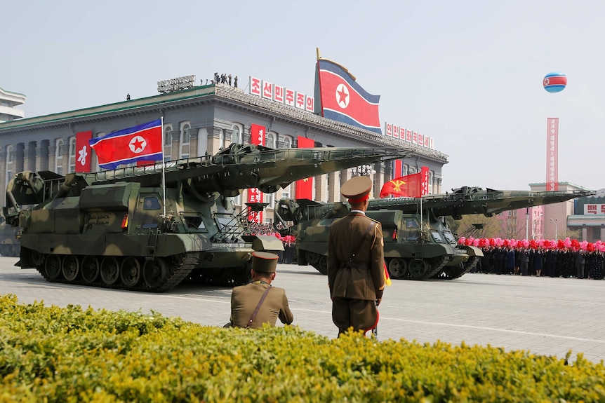 Missiles are driven past the stand with North Korean leader Kim Jong Un and other high ranking officials.