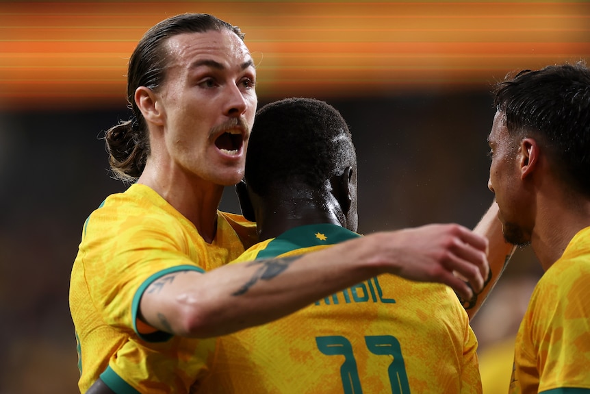 Two men celebrate a goal in a soccer match