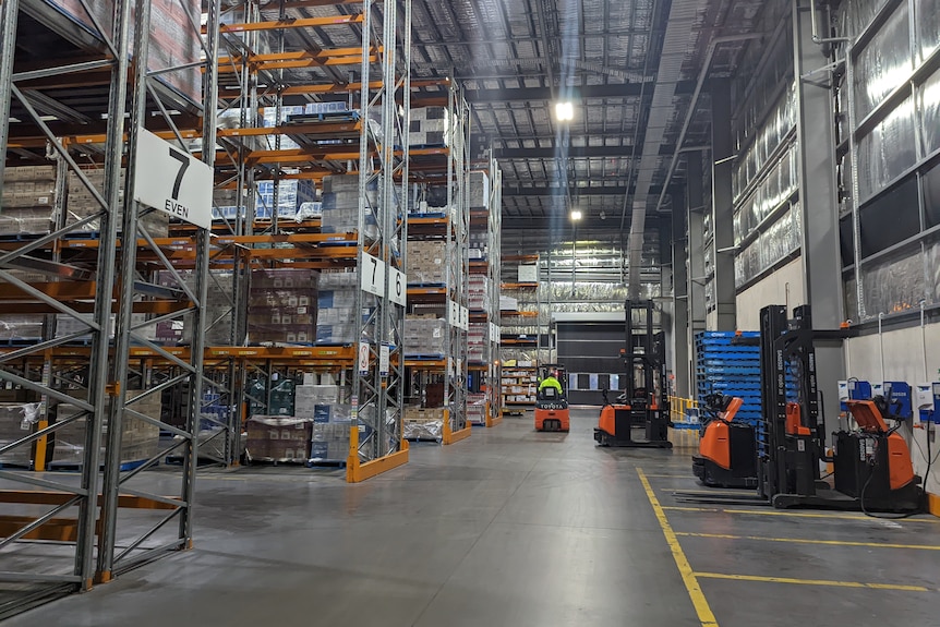 A wine warehouse with shelves containing pallets of wine.