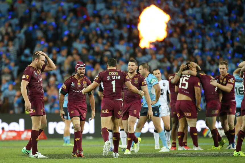 Johnathan Thurston of the Maroons (2nd left) celebrates their victory over the Blues with his team mates.