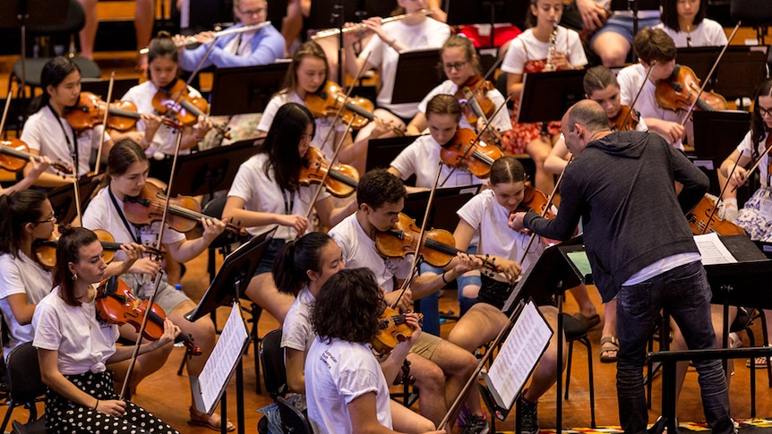 A conductor in front of the Australian Youth Orchestra.