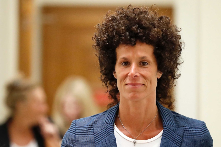 A shot of Andrea Constand - she is visible from the shoulders up and is smiling at the camera