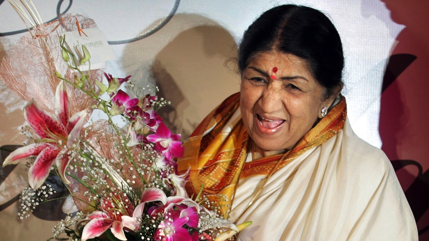 Lata Mangeshkar laughs holding a bouquet at her album launch in this 2007 file photo, Mumbai, India.