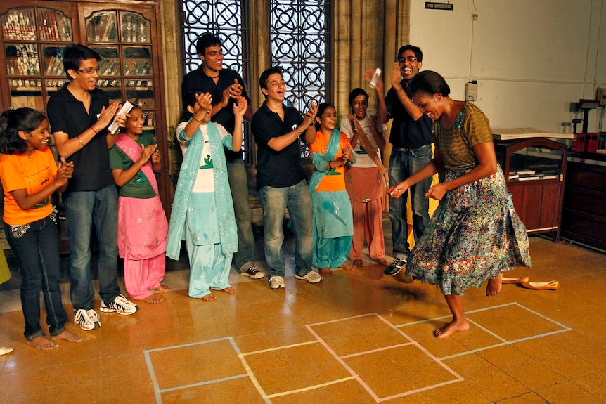 Michelle Obama plays with underprivileged children enrolled in the academic program of "Make A Difference" (MAD), at a university in Mumbai