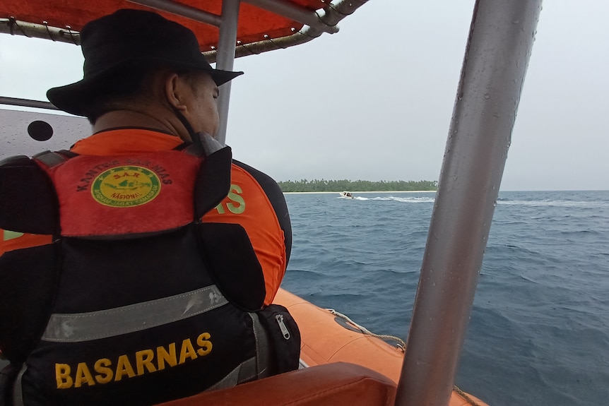 A rescuer in a lifejacket in a small boat. 