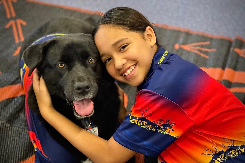 Therapy dog Sheekie and a student.