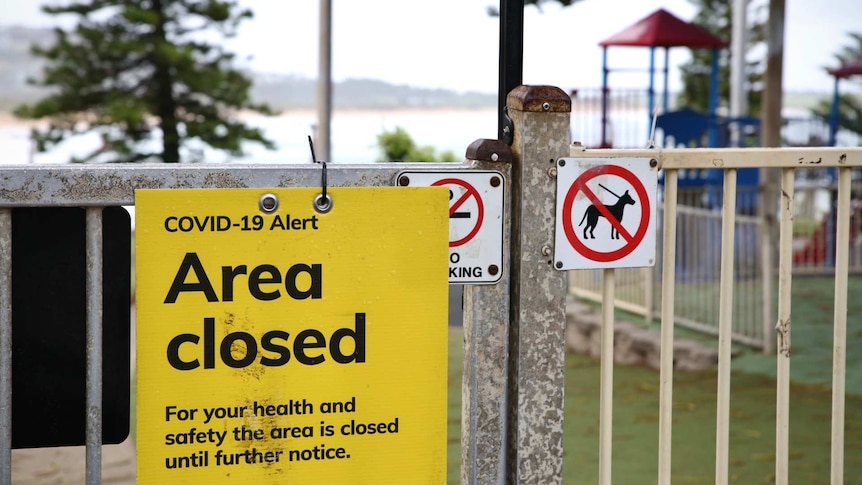 an area closed sign outside a beach playground