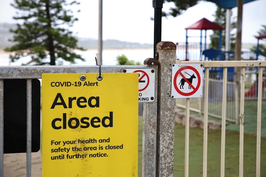 an area closed sign outside a beach playground