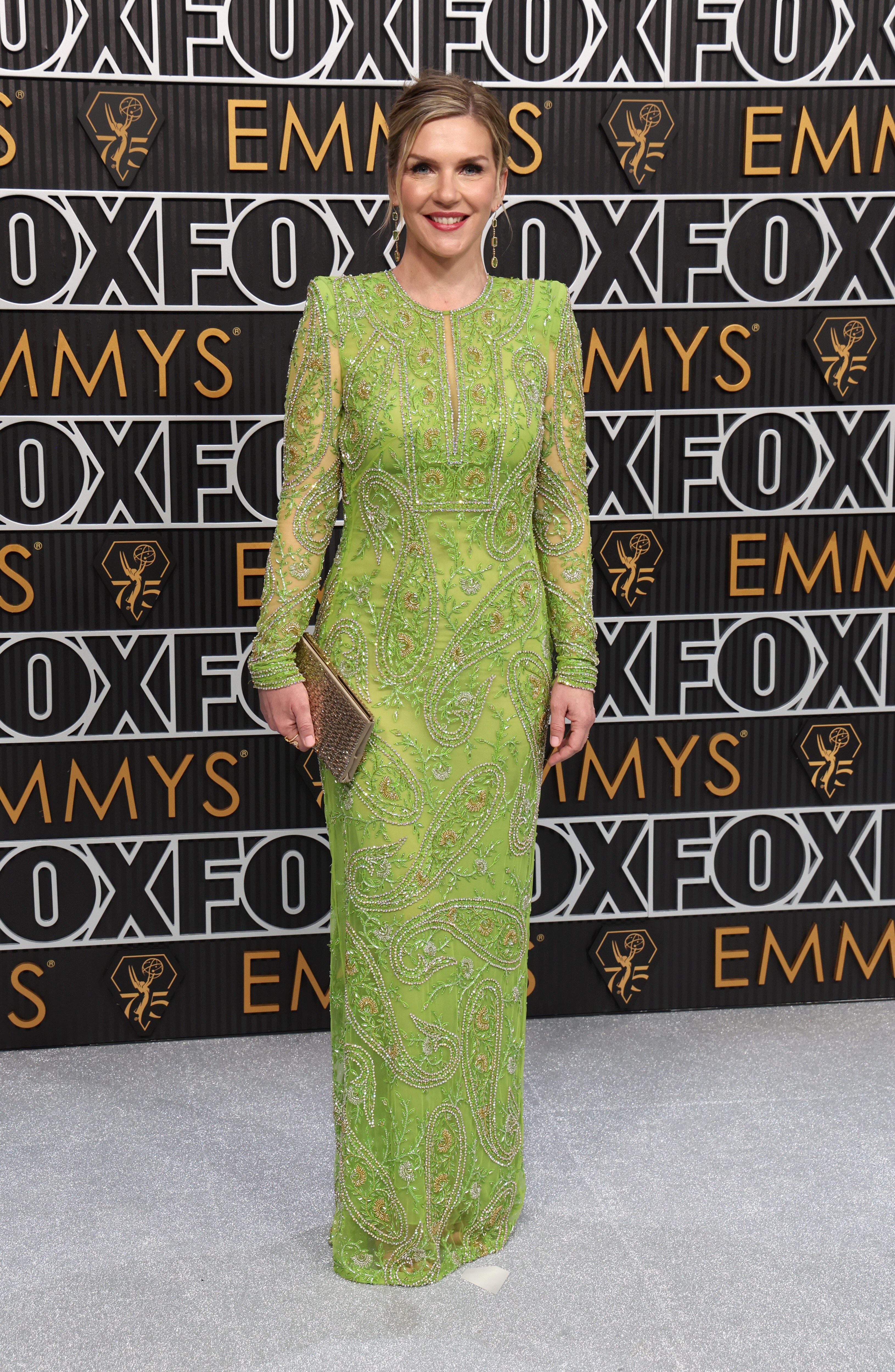 A blond woman in a green dress standing on the red carpet