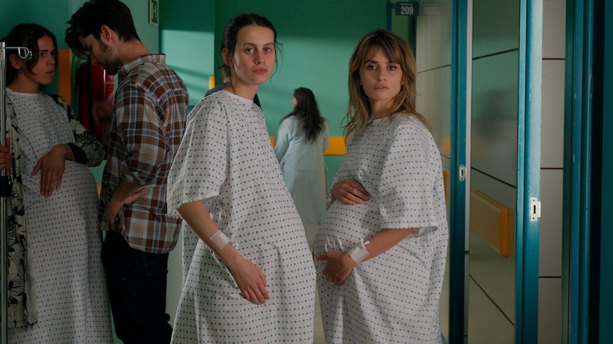 Two heavily pregnant women stand together in the hallway of a maternity ward - one is a teenager, while the other is in her 40s