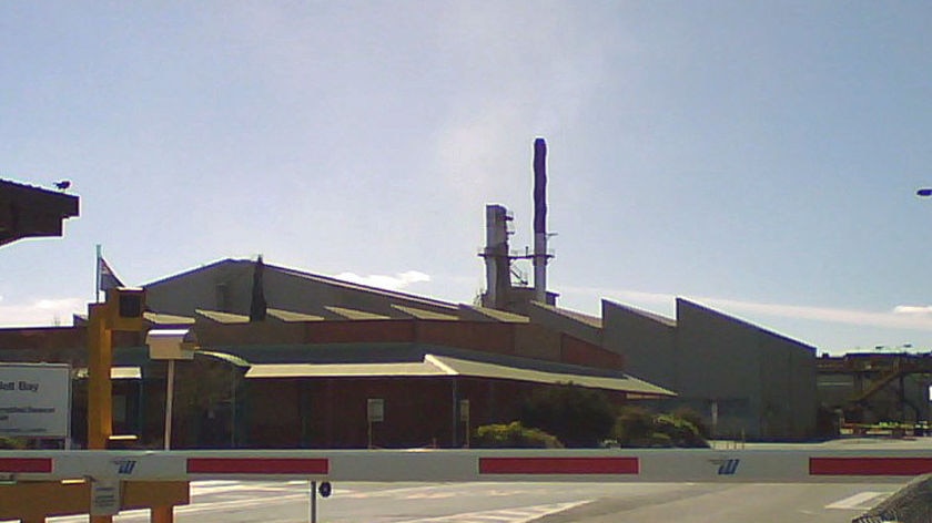 Entrance to Rio Tinto's Bell Bay aluminium smelter in Tasmania with a smoke stack in background.