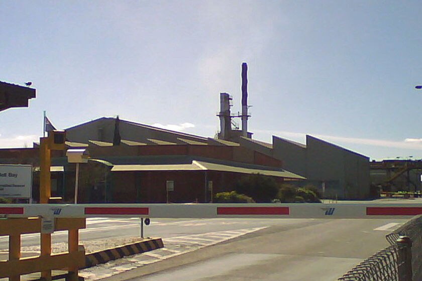 Entrance to Rio Tinto's Bell Bay aluminium smelter in Tasmania with a smoke stack in background.