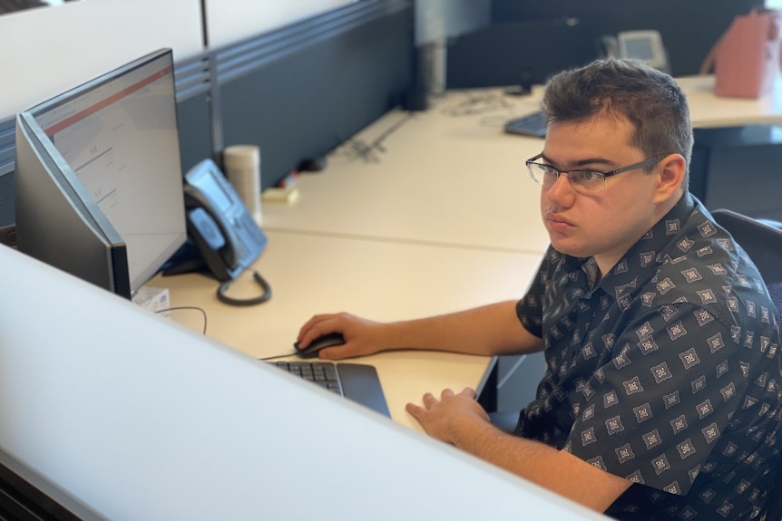 Tom Munro, a service management specialist at BHP, works at his computer.